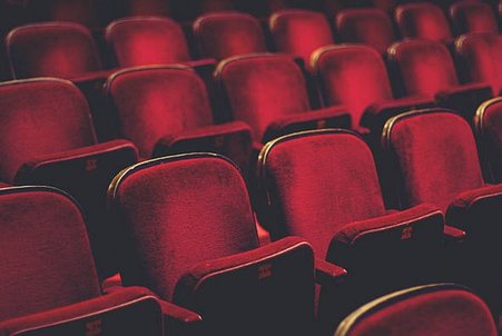 Na zdjęciu widać czerwone siedzenia w teatrze.