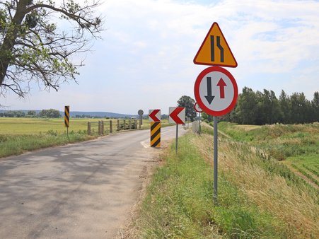 Most nad Kanałem Palemona na trasie Białki–Grabówko z widocznym oznakowaniem drogowym, otoczony zielenią.