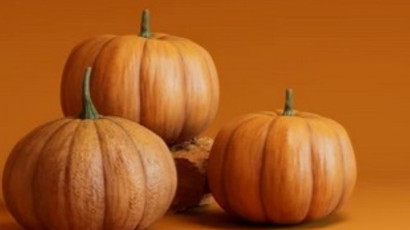 Zdjęcie przedstawia cztery dynie, stojące jedna na drugiej, na pomarańczowym tle.