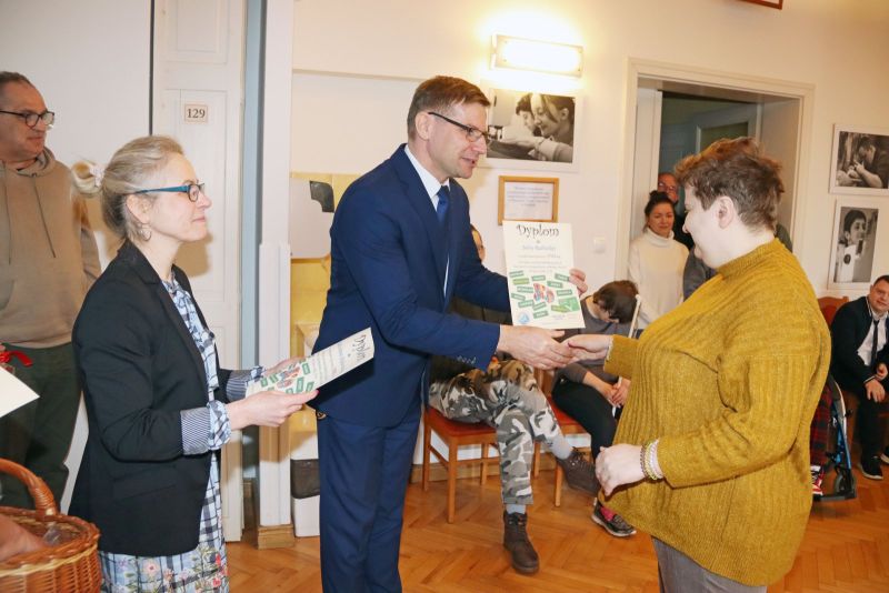 Uczestnicy Warsztatu Terapii Zajęciowej odbierają dyplomy za swoje osiągnięcia. Wręczają je Krzysztof Michalski, zastępca wójta gminy Kwidzyn, oraz opiekunowie WTZ.