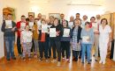 Zdjęcie pamiątkowe uczestników Warsztatu Terapii Zajęciowej po otrzymaniu dyplomów. Wraz z nimi pozują Krzysztof Michalski, zastępca wójta gminy Kwidzyn oraz opiekunowie WTZ.