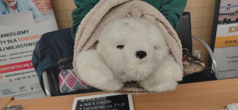 Zdjęcie przedstawia fokę-robota terapeutycznego, stworzonego do wspierania terapii i redukcji stresu u osób w różnym wieku.