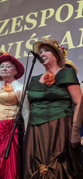 Pani Janina Styczyńska, kierownik  zespołu „Powiślanki” na scenie.