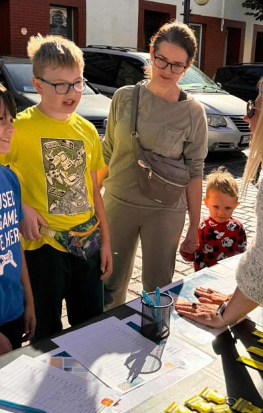zdjęcie przedstawia dzieci stojące przy stoisku. zdjęcie przedstawia dzieci stojące przy stoisku.