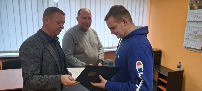 Tomasz Frejnagiel, Starosta Powiatu Kwidzyńskiego, wraz z Jackiem Synakiewiczem, pracownikiem Starostwa Powiatowego, wręczają podziękowanie zaangażowanemu w ćwiczenia uczniowi