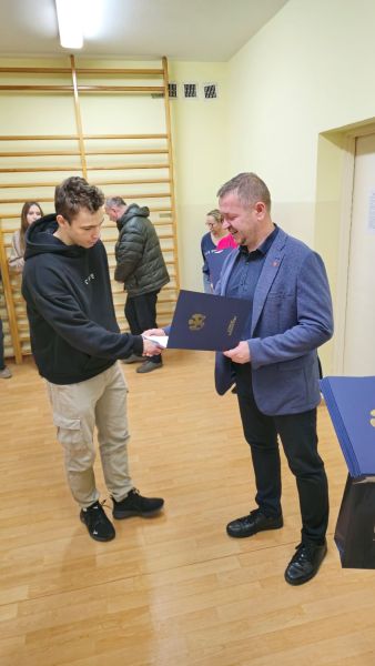 Tomasz Frejnagiel, Starosta Powiatu Kwidzyńskiego, wręcza podziękowanie zaangażowanemu w ćwiczenia uczniowi.