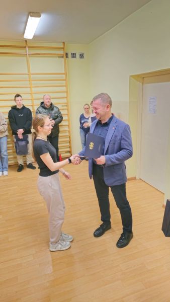 Tomasz Frejnagiel, Starosta Powiatu Kwidzyńskiego, wręcza podziękowanie zaangażowanej w ćwiczenia uczennicy.