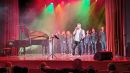 Wokalista Krzysztof Antkowiak wraz z uczestnikami zjazdu na scenie.