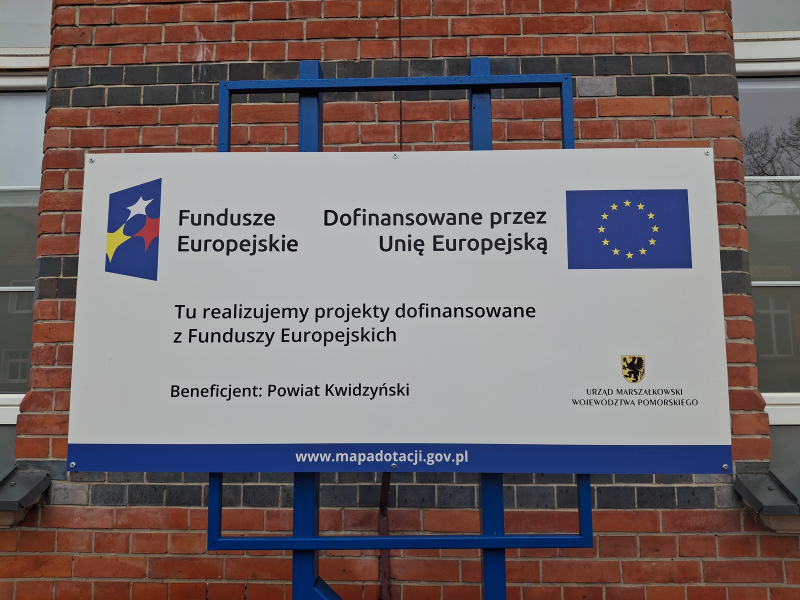 tablica informacyjna na tle budynku Starostwa Powiatowego w Kwidzynie