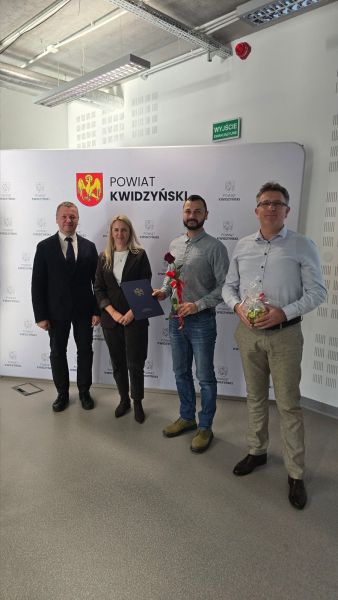 Na zdjęciu widać starostę kwidzyńskiego, kobietę i dwóch mężczyzn pozujących na tle ścianki powiatu kwidzyńskiego Na zdjęciu widać starostę kwidzyńskiego, kobietę i dwóch mężczyzn pozujących na tle ścianki powiatu kwidzyńskiego