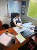 zdjęcie przedstawia zdjęcie przedstawia stażystkę podczas stażu uczniowskiego. Pracuje ona przy biurku z dokumentami;