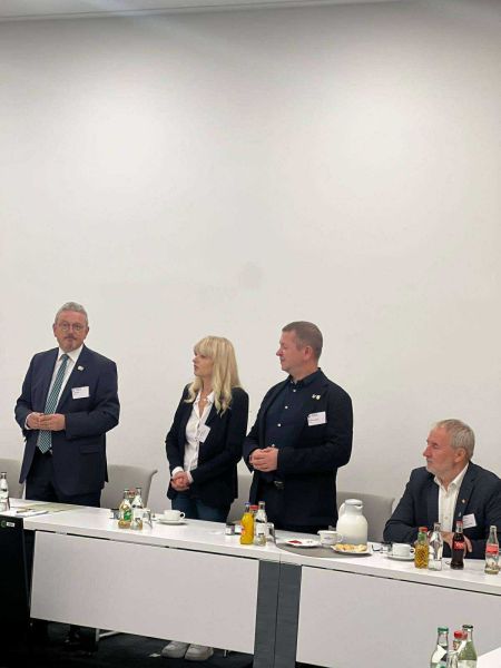 Zdjęcie 1 przedstawia 4 przedstawicieli Powiatu Kwidzyńskiego i Powiatu Osterholz siedzących i stojących.  