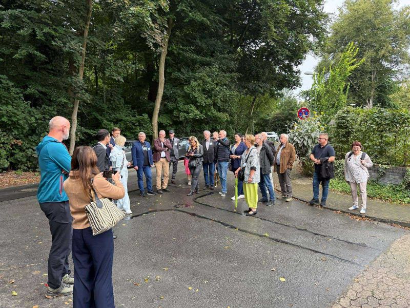 Zdjęcie 3 przedstawia grupę przedstawicieli Powiatu Kwidzyńskiego i Powiatu Osterholz stojących na zewnątrz w półokręgu. 
